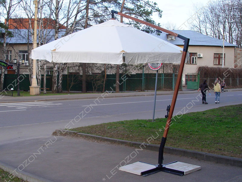 Фото круглого зонта для кафе с боковой опорой на улице
